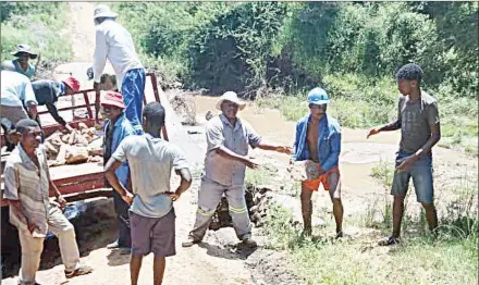  ?? (Courtesy pics). ?? KaMfishane residents who were fixing one of the roads loading stones onto a tractor trailer that was used during the exercise last week.
