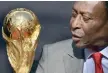  ?? — AFP file photo ?? Brazilian football legend Pele looks at the FIFA World Cup trophy during a FIFA event outside the Hotel de Ville in Paris.