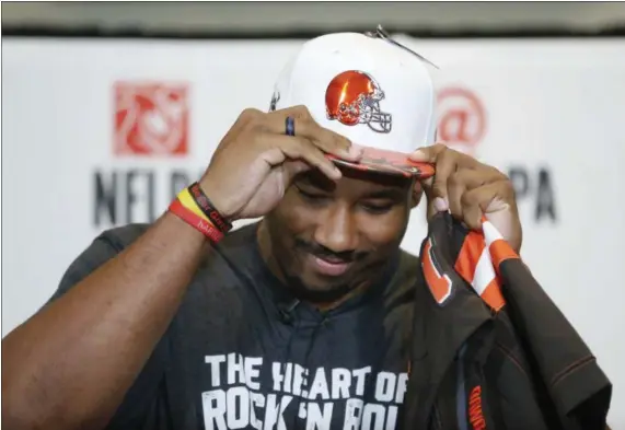  ?? NATHAN HUNSINGER — THE DALLAS MORNING NEWS VIA AP ?? Texas A&M’s Myles Garrett puts on a Browns hat after he was taken as the No. 1 pick in the NFL draft, at Terre Verde Golf Course in Arlington, Texas, on April 27.