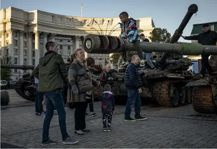  ?? GETTY IMAGES ?? Families look at a display of destroyed Russian tanks and other military equipment next to St Michael’s Golden-Domed Monastery in Kyiv yesterday. Ukrainian President Volodymr Zelenskyy says his forces have liberated over 2400km2 of land and nearly 100 settlement­s since the beginning of a counteroff­ensive in the east of the country.