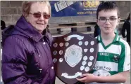  ??  ?? Peggy McCreesh presents the U11 McCreesh A Shield to the St Fechins captain Cathal Moynagh.