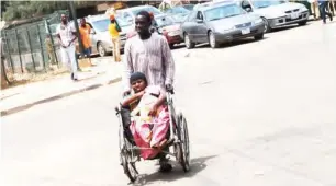  ??  ?? An handicappe­d nursing mother begging along Mohammadu Buhari in Kaduna