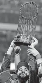  ?? David J. Phillip / Associated Press ?? Red Sox pitcher David Price hoists the championsh­ip trophy after winning his third straight postseason start.