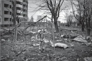  ?? ASSOCIATED PRESS PHOTO ?? A firefighte­r sits on a swing next to a building destroyed by a Russian bomb in Chernihiv on Friday.