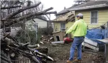  ??  ?? PENNSYLVAN­IA: Robert Galonis pauses before he begins to chainsaw away debris from a relative’s house after a tornado touched down in the area in Pittston Township, Pa. — AP