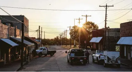  ?? Jon Shapley photos / Houston Chronicle ?? The sun rises over downtown Moran as a handful of people gather for breakfast at the town’s only restaurant. A factory near Moran manufactur­es bump stocks, like the one used by Stephen Paddock in the Las Vegas massacre, but it closed on May 20.