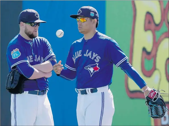  ?? — THE CANADIAN PRESS FILES ?? Blue Jays pitchers Drew Storen, left, and Roberto Osuna chat while shagging fly balls at spring training in Dunedin, Fla. The two have become good friends and Osuna says the most important thing for each of them is how they can help the team.
