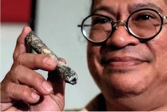  ??  ?? ABOVE: Associate Professor Armand Salvador Mijares of the University of the Philippine­s holds up a bone of the newly discovered human foreunner, Homo luzonensis. BELOW: The carved gemstones unearthed in Hexham.