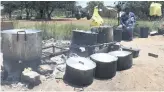  ?? ?? TRADITIONA­L. Zandile Molefe prepares meals on Solomon Mahlangu Drive.