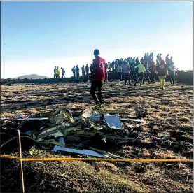  ?? AP/YIDNEK KIRUBEL ?? Searchers examine the scene Sunday where the Ethiopian Airlines jetliner crashed. Eight Americans were among the 157 people who died.