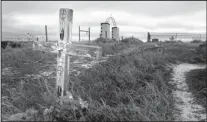  ?? RAPID CITY JOURNAL/THE ASSOCIATED PRESS ?? A cross on a grave at the Wounded Knee National Historic landmark in South Dakota. Wednesday was the final day for the Oglala Sioux to make an offer to buy a portion of the site.