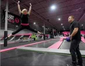  ?? CATHIE COWARD, THE HAMILTON SPECTATOR ?? Emma Reilly working out at Flying Squirrel trampoline park, with the help of owner Luke Schueler.