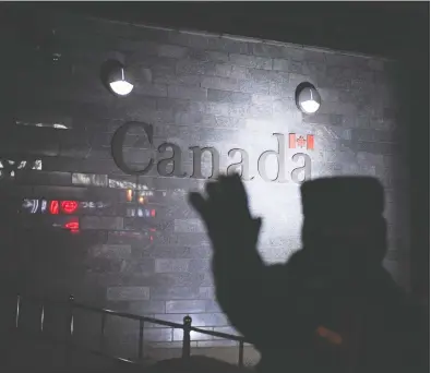  ?? GREG BAKER / AFP VIA GETTY IMAGES FILES ?? A guard tries to block photos being taken as he patrols outside the Canadian embassy in Beijing. There is a growing
consensus that Canada should be tougher on China but there is only so much Canadians can realistica­lly do.