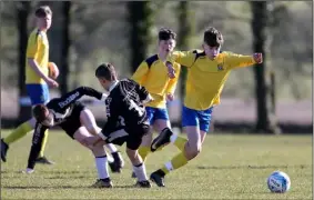  ??  ?? Adamstown’s Paddy Doyle slips the ball past Cian O’Brien (Corach Ramblers).