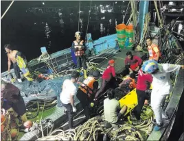  ??  ?? Thailand Royal Police Rescued tourists from a boat that sank are helped onto a pier from a fishing boat Thursday on the island of Phuket, southern Thailand.