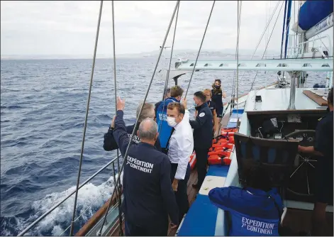  ??  ?? Macron talks Friday with the crew of the 7th Continent expedition sailing ship near Marseille.