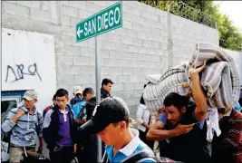  ?? ASSOCIATED PRESS ?? CENTRAL AMERICAN MIGRANTS WAIT IN LINE for a meal at a shelter in Tijuana, Mexico, on Wednesday.