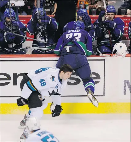  ?? MARK VAN MANEN/PNG ?? Vancouver Canucks defenceman Alex Edler flies into the bench as he knocks the helmet off of San Jose rookie Tomas Hertl Thursday at Rogers Arena. The hit may be reviewed by the NHL.