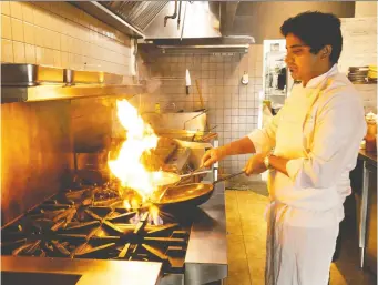  ?? ERROL MCGIHON ?? Chef/owner Teegavarap­u Sarath Mohan cooks in his new restaurant Vivaan on Preston Street.