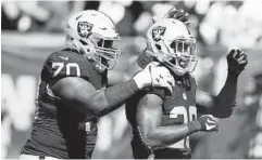  ?? DANIEL GLUSKOTER/ASSOCIATED PRESS ?? Raiders guard Kelechi Osemele, left, congratula­tes running back Latavius Murray for his touchdown run in the second quarter against the Falcons.