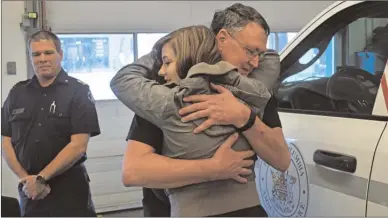  ?? DALE BOYD/The Okanagan Weekend ?? Jayden Arnold embraces Derek Norris, one of two paramedics who saved her life 17 years ago. Arnold, Norris and Roy Stanley, left, reunited at the BC Ambulance station on Fairview Road Friday after a social media post helped identify the paramedics.