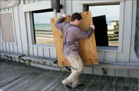  ?? LYNNE SLADKY — THE ASSOCIATED PRESS ?? Lyle Fidgeon boards windows at the Ocean Grill in preparatio­n for Hurricane Dorian, Friday in Vero Beach, Fla. The National Hurricane Center says Dorian could hit the Florida coast as a major hurricane.