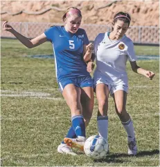  ?? JANE PHILLIPS/FOR THE NEW MEXICAN ?? St. Michael’s Frances Schneider and Academy for Technology and the Classics’ Justice Salazar battle for the ball Saturday at Christian Brothers Athletic Complex in the Girls State Soccer Tournament. St. Michael’s won 9-1.