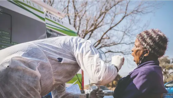  ?? PHOTOS: GULSHAN KHAN/ THOMSON REUTERS FOUNDATION ?? A health-care worker swabs Gladys Moletsane, 76, outside Pudumong Healthcare Centre in the North West Province, South Africa.