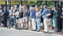  ??  ?? All eyes . . . People watch the cars depart.