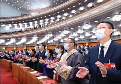  ?? RAO AIMIN / XINHUA ?? Deputies to the 14th National People’s Congress respond at the closing meeting in Beijing on March 13.