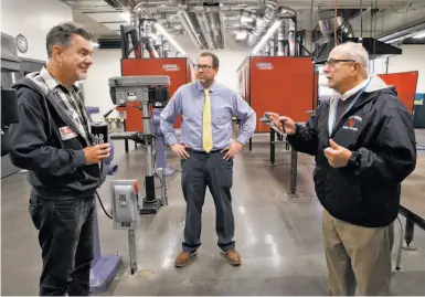  ?? Photos by Paul Chinn / The Chronicle ?? Potential teacher applicant Mark Metz (left) tours new welding and metal shop classroom at Kennedy High in Richmond with assistant principal Andrew Brooks (center) and retired teacher Mike Peritz.