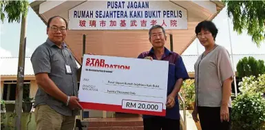  ??  ?? Generous gift: The Star’s assistant news editor Arnold Loh (left) presenting the mock cheque from Star Foundation to Chong while Chung looks on at the home in Perlis.