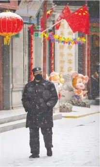  ?? MARK SCHIEFELBE­IN/AP ?? A guard walks along a shopping street in Beijing in February. The Trudeau government’s timidity is embarrassi­ng, given China’s wrongdoing and the outrage here at home, says Diane Francis.