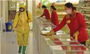  ?? (AFP) ?? This file photo shows employees disinfecti­ng surfaces at the Pyongyang Children’s Department Store in Pyongyang on March 18 this year