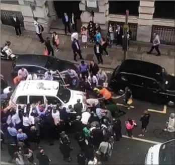  ??  ?? Rescue effort: Londoners come to the aid of a woman trapped under a cab in the City last week