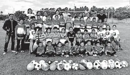  ??  ?? ONE BIG FAMILY. Athletes, parents and coaches of the Panabo Parents United Football Club gather for a photo opportunit­y after a training session.