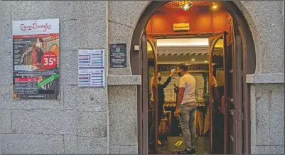  ??  ?? A staff worker checks a customer’s body temperatur­e before he enters the Torres Bermeja.