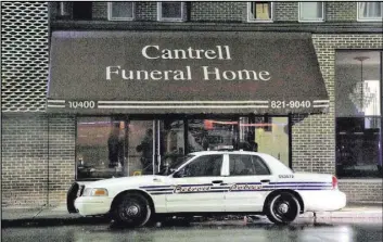  ?? Junfu Han The Associated Press ?? A Detroit police vehicle is parked Friday outside the Cantrell Funeral Home, where Michigan inspectors found badly decomposed remains of 11 infants hidden in a ceiling compartmen­t.