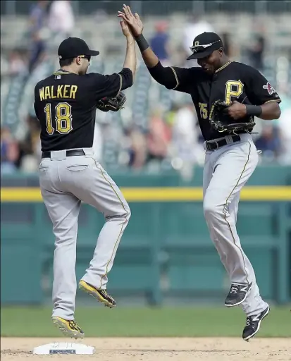  ?? Carlos Osorio/Associated Press photos ?? Neil Walker, left, and Gregory Polanco celebrate the Pirates’ 8-4 win against the Tigers Thursday in Detroit.