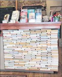  ?? AP PHOTO ?? The check-out counter at the indie bookseller Newtonvill­e Books in Newton, Mass. The counter is made of rows of backwards books glued into place.