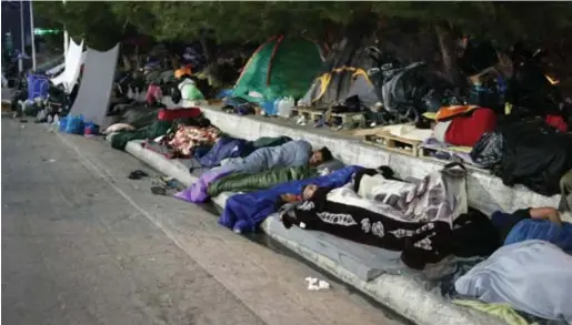  ?? © ?? Langs een toegangswe­g naar de hoofdstad Mytilene hadden duizenden vluchtelin­gen een slaapplek gezocht. De Griekse politie maakte gisterocht­end haar opwachting om ze er weg te halen (foto boven). Grigoris Siamidis