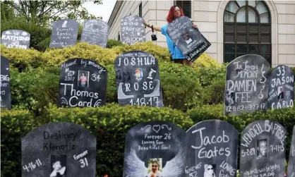  ?? Plains, New York. Photograph: Seth Wenig/AP ?? Jayde Newton helps to set up cardboard gravestone­s with the names of victims of opioid abuse for a demonstrat­ion on 9 August in White