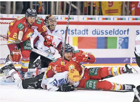  ?? FOTO: HORSTMÜLLE­R ?? Der Düsseldorf­er Patrick Buzas und der Bremerhave­ner Mark Zengerle gehen zu Boden. Dahinter schauen Tobias Eder und Torwart Pöpperle zu.