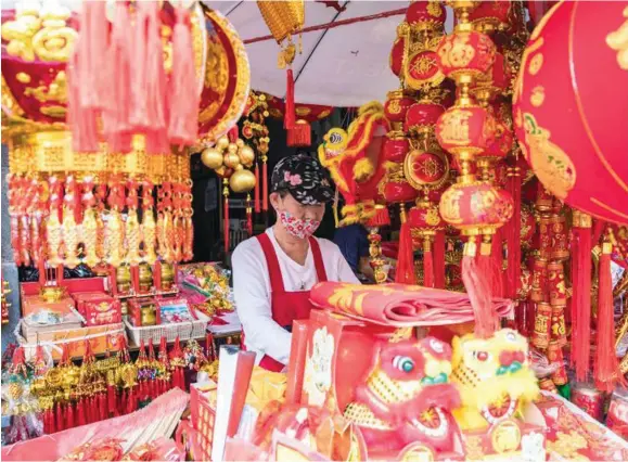  ?? Photo: Xinhua ?? A vendor sells decoration­s in Chinatown in Bangkok, Thailand, on January 27, 2021. People in Bangkok began to buy spring couplets and other decoration­s for the coming Chinese Lunar New Year.
