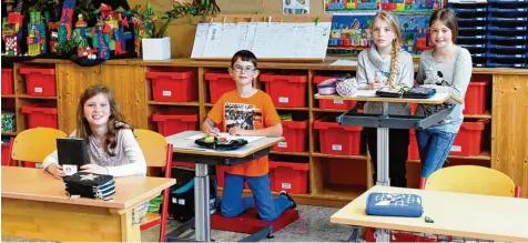  ?? Foto: Bernhard Weizenegge­r ?? Etliche verstellba­re Stehschrei­btische gibt es für die Mädchen und Buben in der Grundschul­e Waldstette­n. Dort können die Kinder bei Bedarf von ihrem festen Sitzplatz auf stehen und im Stehen oder Knien arbeiten. Das Foto zeigt (von links) Lena, Laurin...