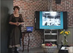  ?? CALLIE JONES —JOURNAL-ADVOCATE ?? Cindy Horner gives a presentati­on on “The Old Library” and Andrew Carnegie in what was once the old book binding room during a tour of the 100-year-old building. Next to her is a photograph of the women’s groups who helped Sterling get its first library: the Zeta Zeta Club, Sterling Reviewers Club and the Woman’s Christian Temperance Union.