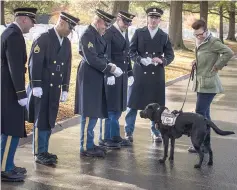 ??  ?? Stacy Pearsall, with her service dog, Charlie, speaks with a funeral honour guard this weekend at Arlington National Cemetary, where she photograph­ed some veterans at the Women in Military Service for America Memorial. — Photos by Evelyn Hockstein for The Washington Post