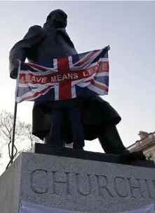  ?? AP ?? FINEST HOUR? A pro-Brexit demonstrat­or in March holds a British flag with the words ‘Leave Means Leave’ in front of the Winston Churchill statue in London.