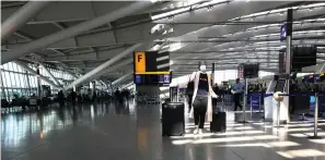  ?? Associated Press ?? ■ A woman wears a mask March 24 as she walks through a quieter-than-usual Heathrow Airport Terminal 5 in London. Air traffic is down 92% this year as travelers worry about catching COVID19 and government travel bans and quarantine rules make planning difficult. One thing airlines believe could help is to have rapid virus tests of all passengers before departure.