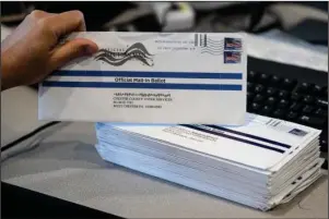  ?? The Associated Press ?? MAIL-IN BALLOTS: In this May 28 file photo, Dave Turnier processes mail-in ballots at at the Chester County Voter Services office in West Chester, Pa., prior to the primary election. President Donald Trump’s campaign and allies have blocked efforts to expand mail-in voting, forcing an awkward confrontat­ion with top GOP election officials promoting the opposite in their states. The rare dissonance between Trump and other Republican elected officials also reflects another reality that the president will not concede: Many in his party believe expanding mail-in voting could ultimately help him.